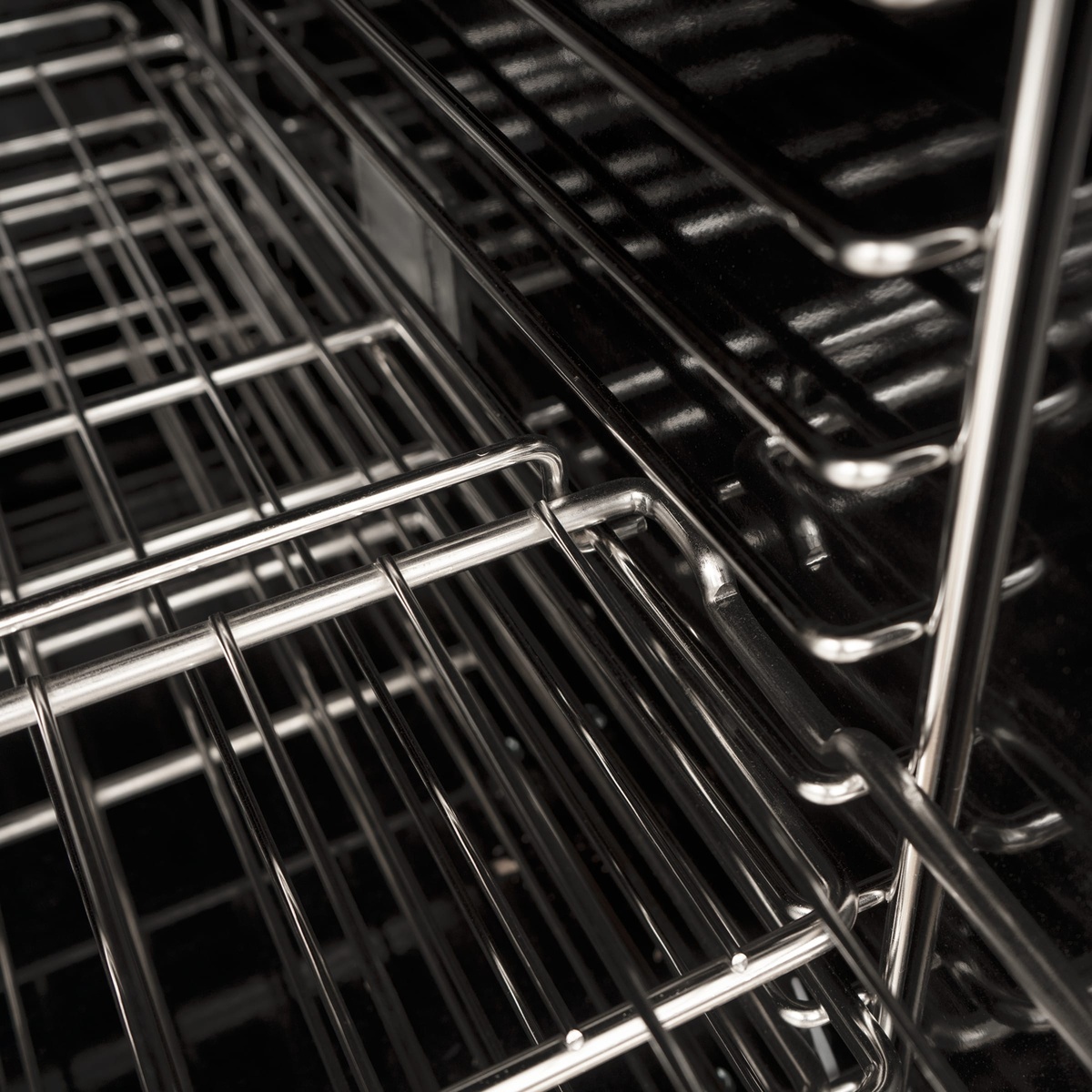 Close-up of chrome-plated oven rack and multiple rack guides inside the oven cavity
