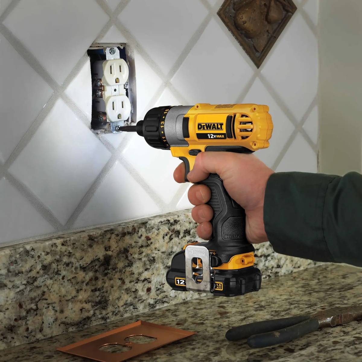 DEWALT DCF610S2 12V MAX 1/4 in screwdriver kit driving a fastener at an electrical outlet in a kitchen backsplash installation