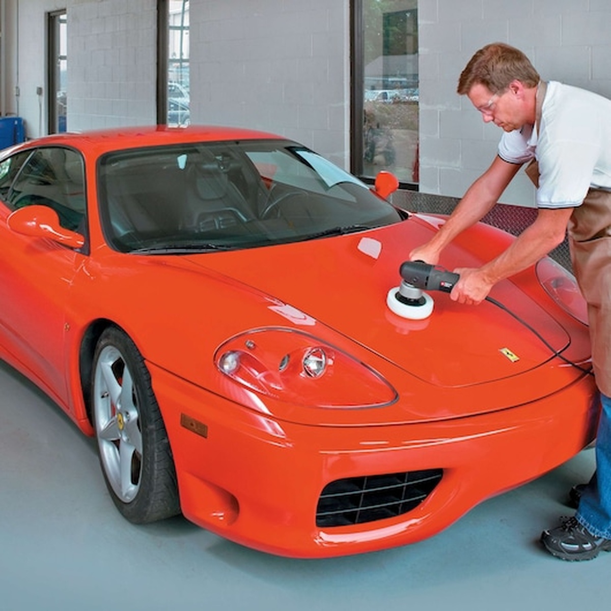 Porter Cable 7346SP 6 in. Variable-Speed Random Orbit Sander with Polishing Pad polishing an automotive hood during paint correction work in a garage