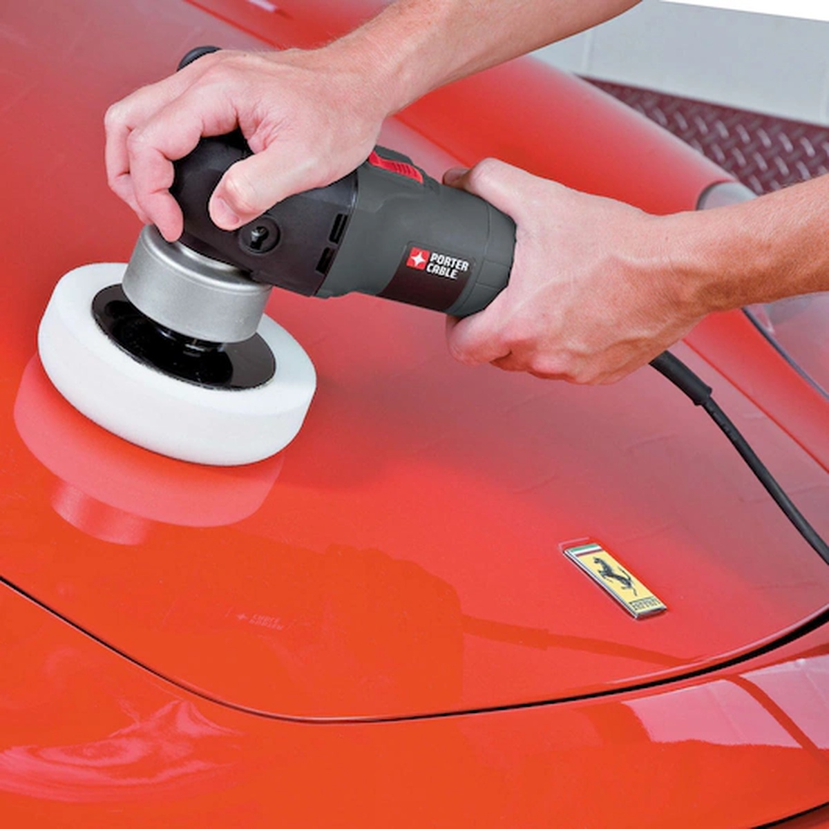 Porter Cable 7346SP 6 in. Variable-Speed Random Orbit Sander with Polishing Pad used by hand on an automotive panel for controlled polishing
