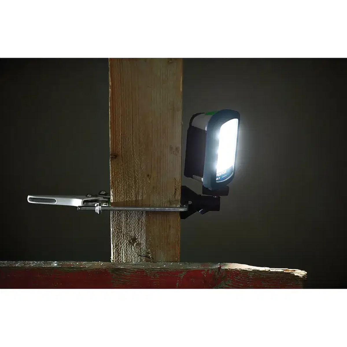 Festool 499814 SysLite Magnetic Mount Head supporting a SysLite work light on framing lumber for focused task lighting in a dark workspace