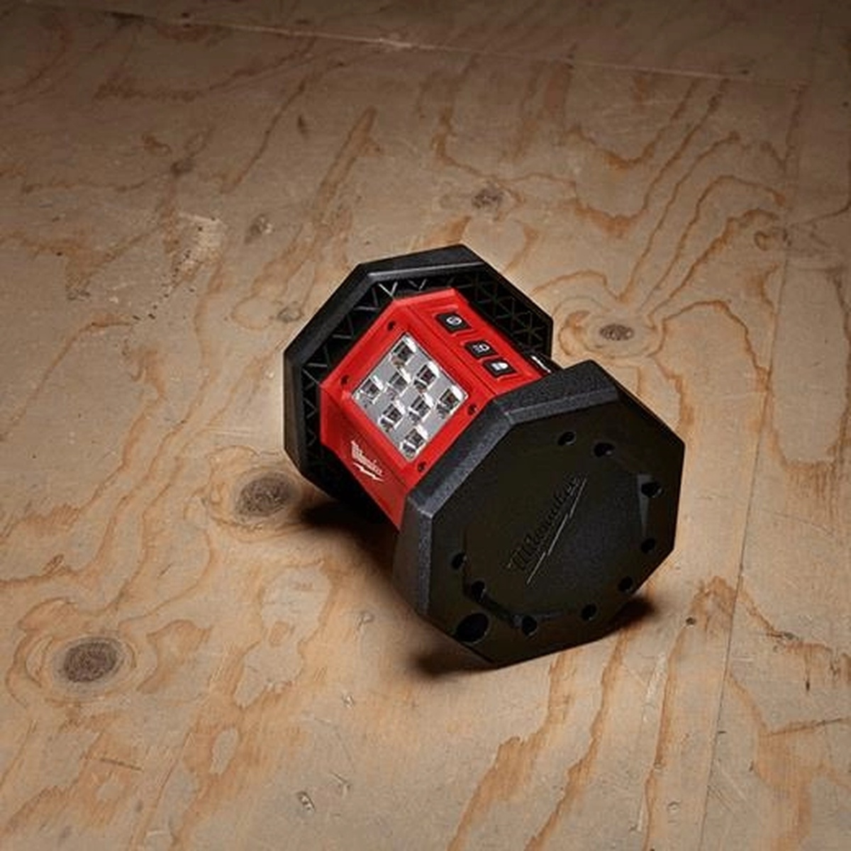 Milwaukee M18 ROVER Flood Light (Tool-Only) resting on a plywood subfloor at an angle for portable area lighting during remodeling and interior construction