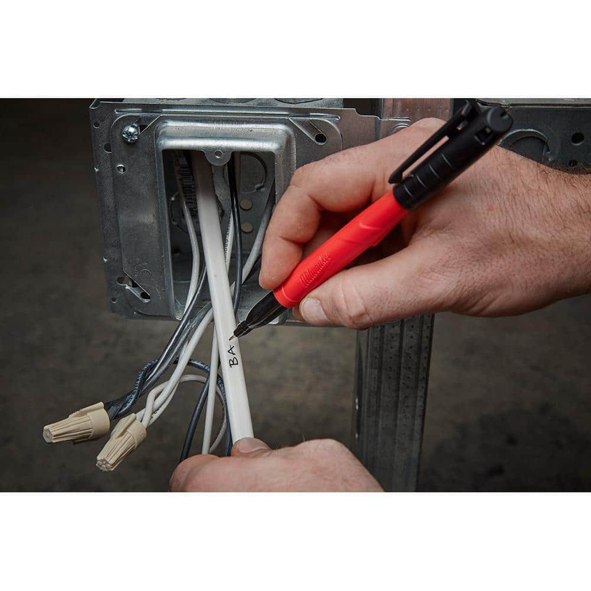 Milwaukee INKZALL Black Fine Point Jobsite Permanent Marker labeling electrical wire during rough-in work inside metal framing