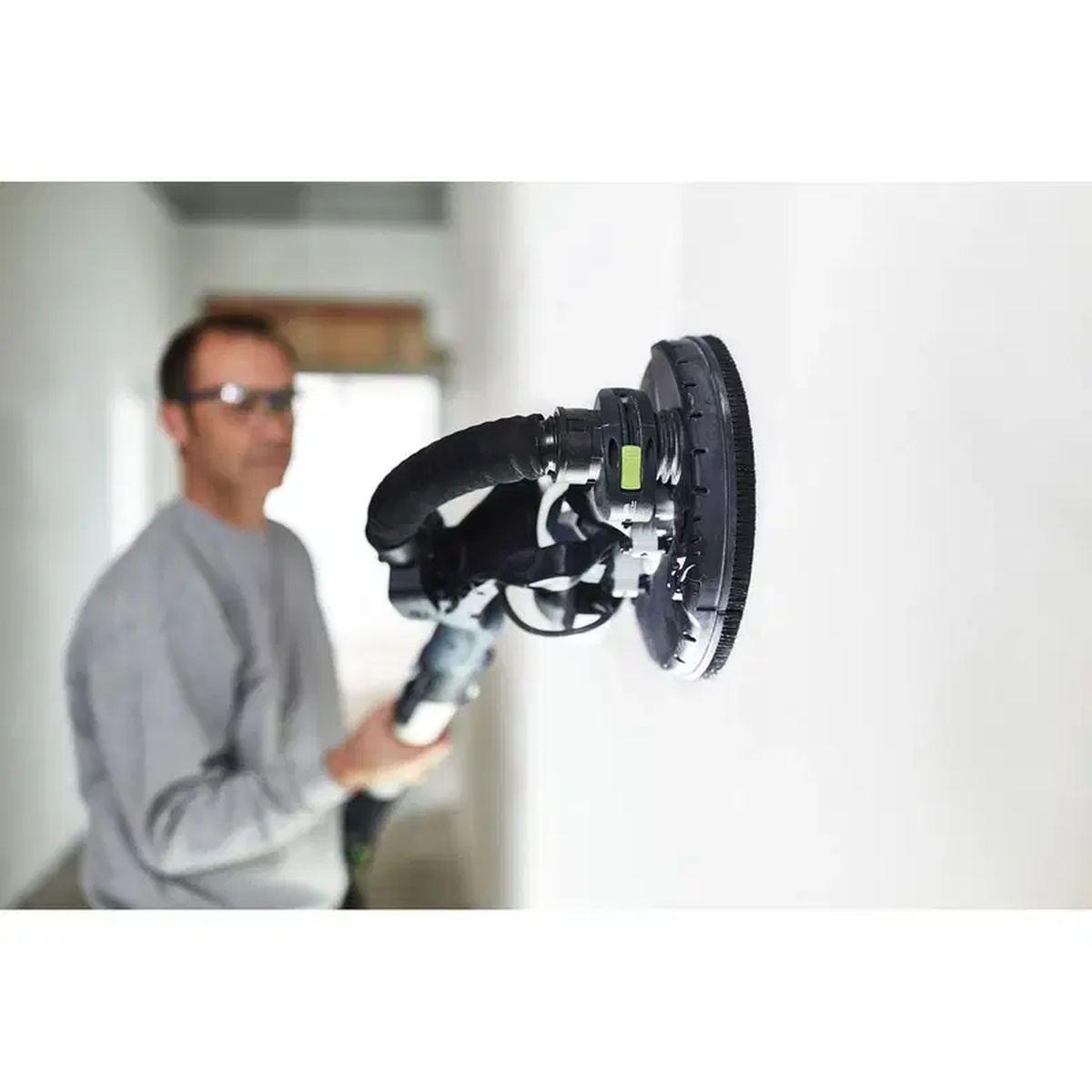 Festool 496140 Planex Interface Pad installed on a PLANEX drywall sander smoothing wall compound during interior drywall finishing