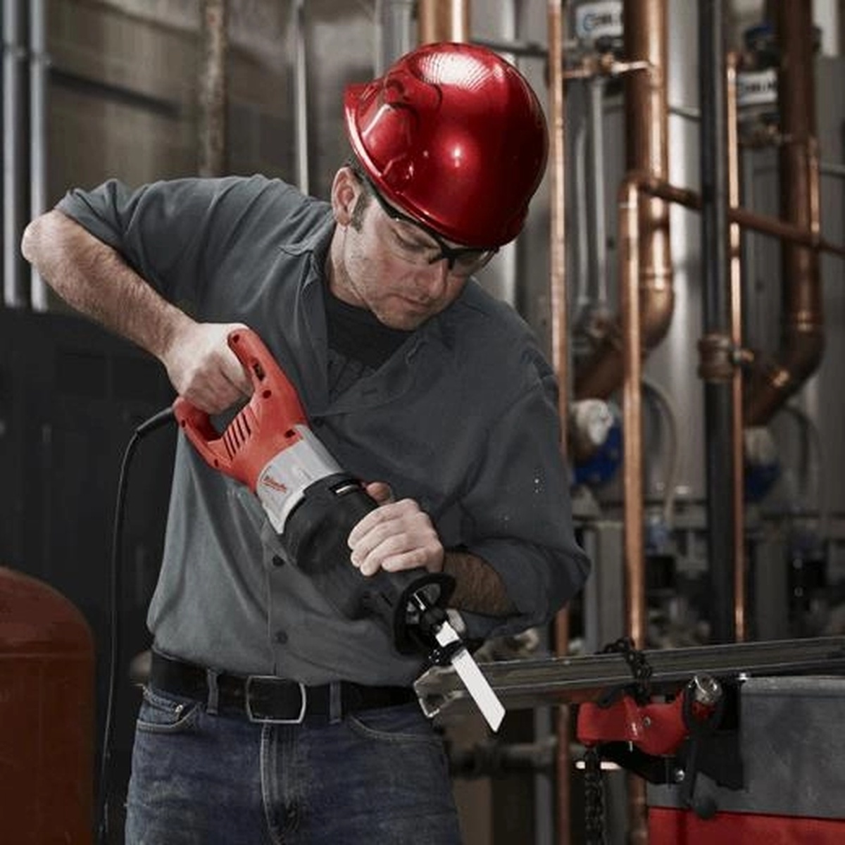 Milwaukee 6538-21 15.0 Amp Super Sawzall Reciprocating Saw cutting metal pipe in a mechanical room jobsite application