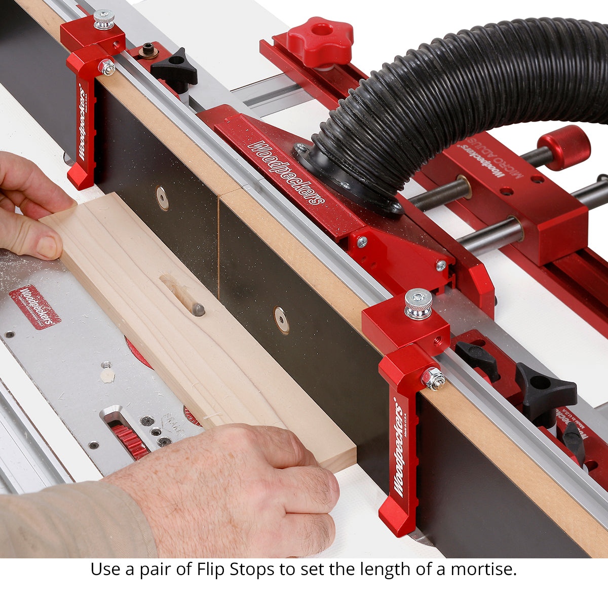 Woodpeckers STFSTOP Super Track Flip Stop used on a router table fence to position a wood board for repeatable routing work in a woodworking shop