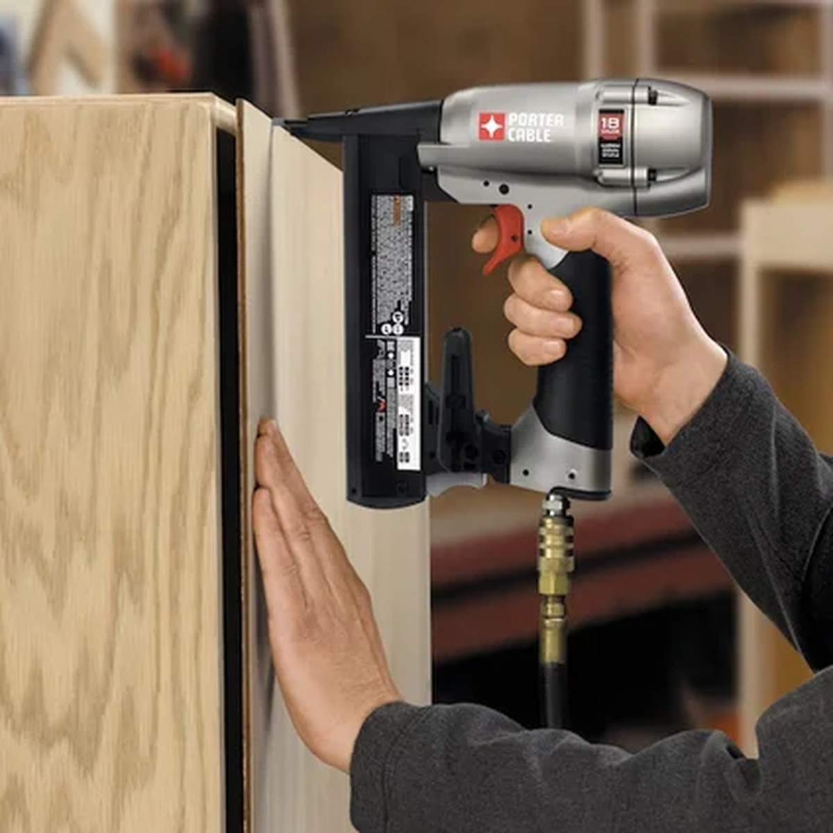 Porter Cable NS150C Pneumatic 18-Gauge 1-1/2 in. Narrow Crown Stapler Kit fastening cabinet material during woodworking assembly in a shop setting