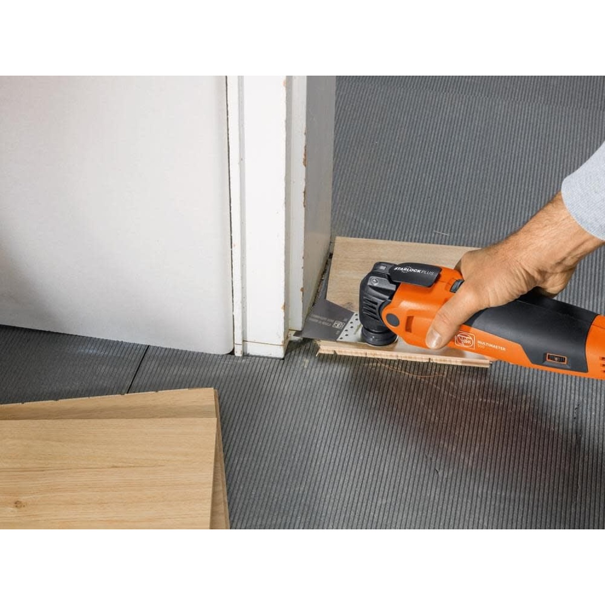 Fein MultiMaster MM 500 Start Q Oscillating Multi-Tool flush cutting flooring at a door jamb during installation work