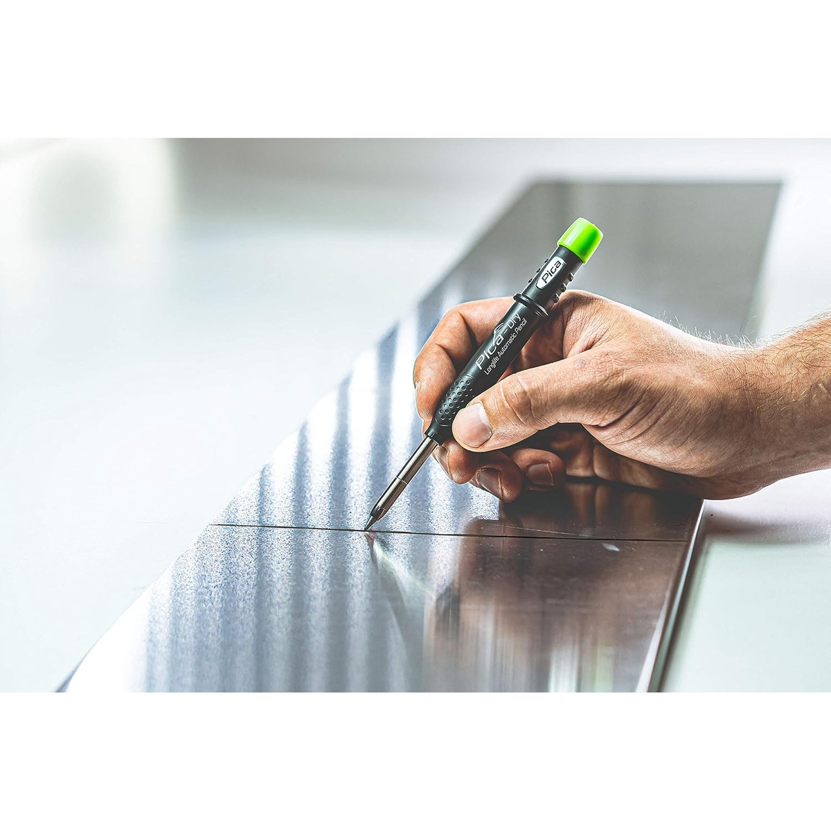 Pica Dry 3030-4030 Longlife Automatic Pencil and Graphite Refill Set marking a layout line on sheet metal in a workshop setting
