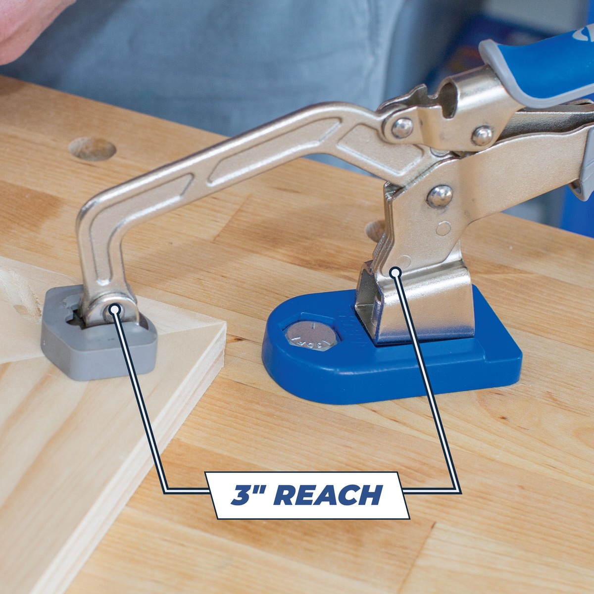 Kreg KBC3-BAS Bench Clamp with Bench Clamp Base securing a wood panel on a workbench during woodworking assembly