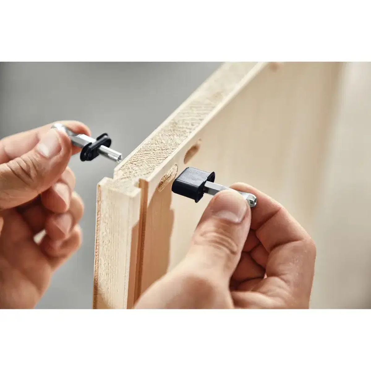 Festool 203167 Domino DF 500 8mm Center Panel Connector being installed into a cabinet panel edge during furniture assembly in a woodworking shop