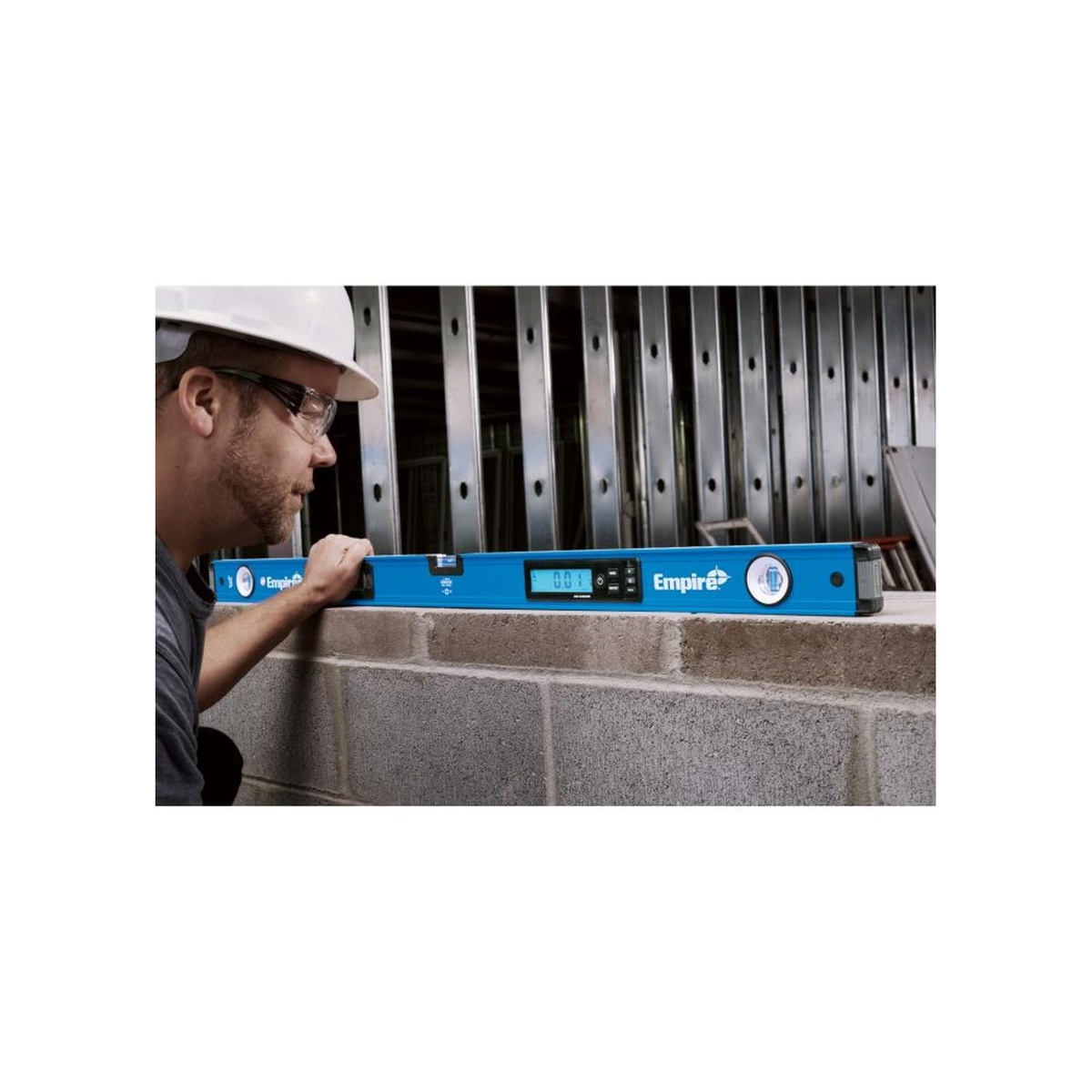 Empire E105.48 48-Inch Digital Box Level checking level across a concrete block wall on a construction jobsite