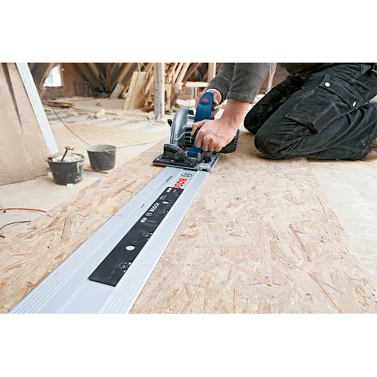 Bosch FSNVEL 14 In. Track Connector installed in a Bosch track saw guide rail during plywood cutting on a jobsite floor
