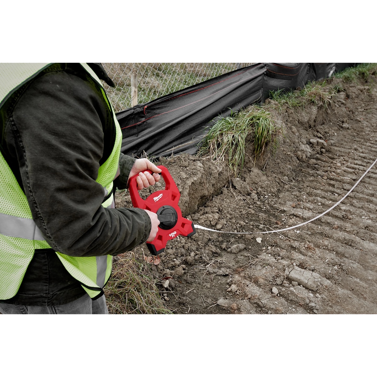 Milwaukee 48-22-5302 200Ft Fiberglass Open Reel Long Tape being rewound during site layout work along a trench line