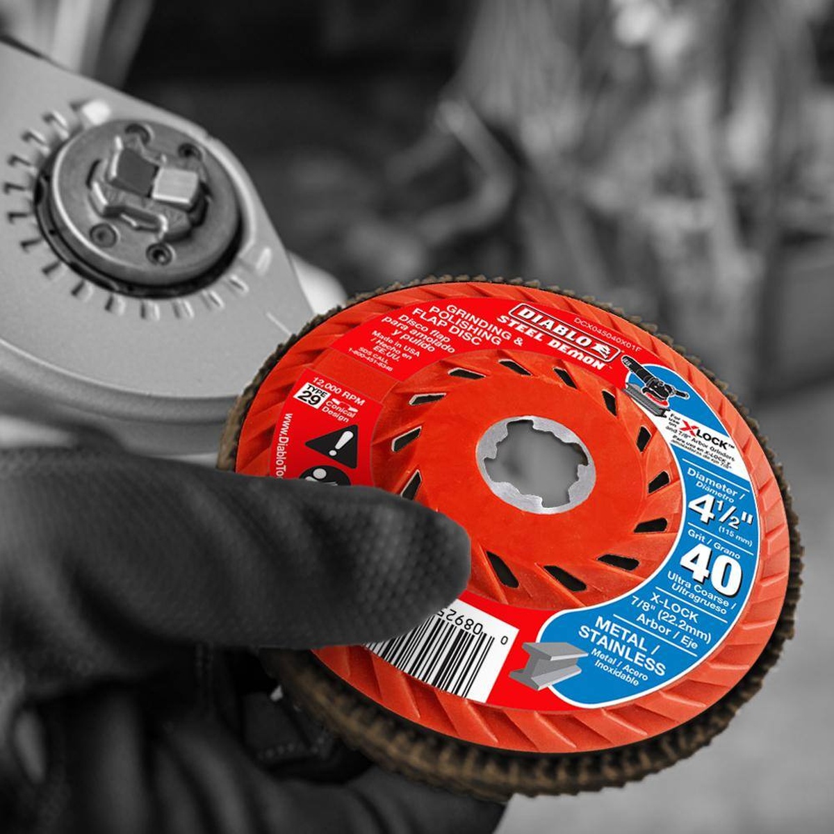 Diablo DCX045040X01F 4-1/2 Inch 40-Grit Flap Disc being mounted to an angle grinder for metal grinding work in a shop setting
