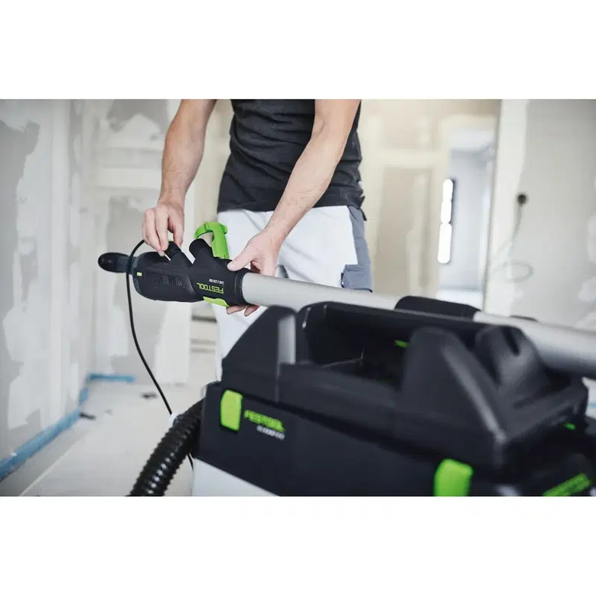 Festool PLANEX long-reach sander being set onto a CT extractor with the WHR-CT LHS 2 tool holder on an interior remodeling jobsite