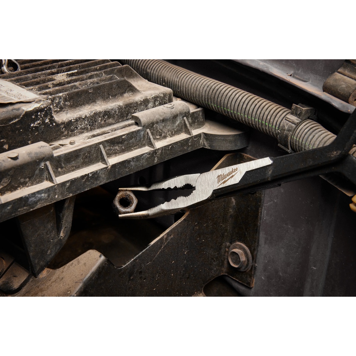 Milwaukee 48-22-6540 13 inch long reach straight nose pliers gripping a fastener inside a tight engine bay during automotive repair