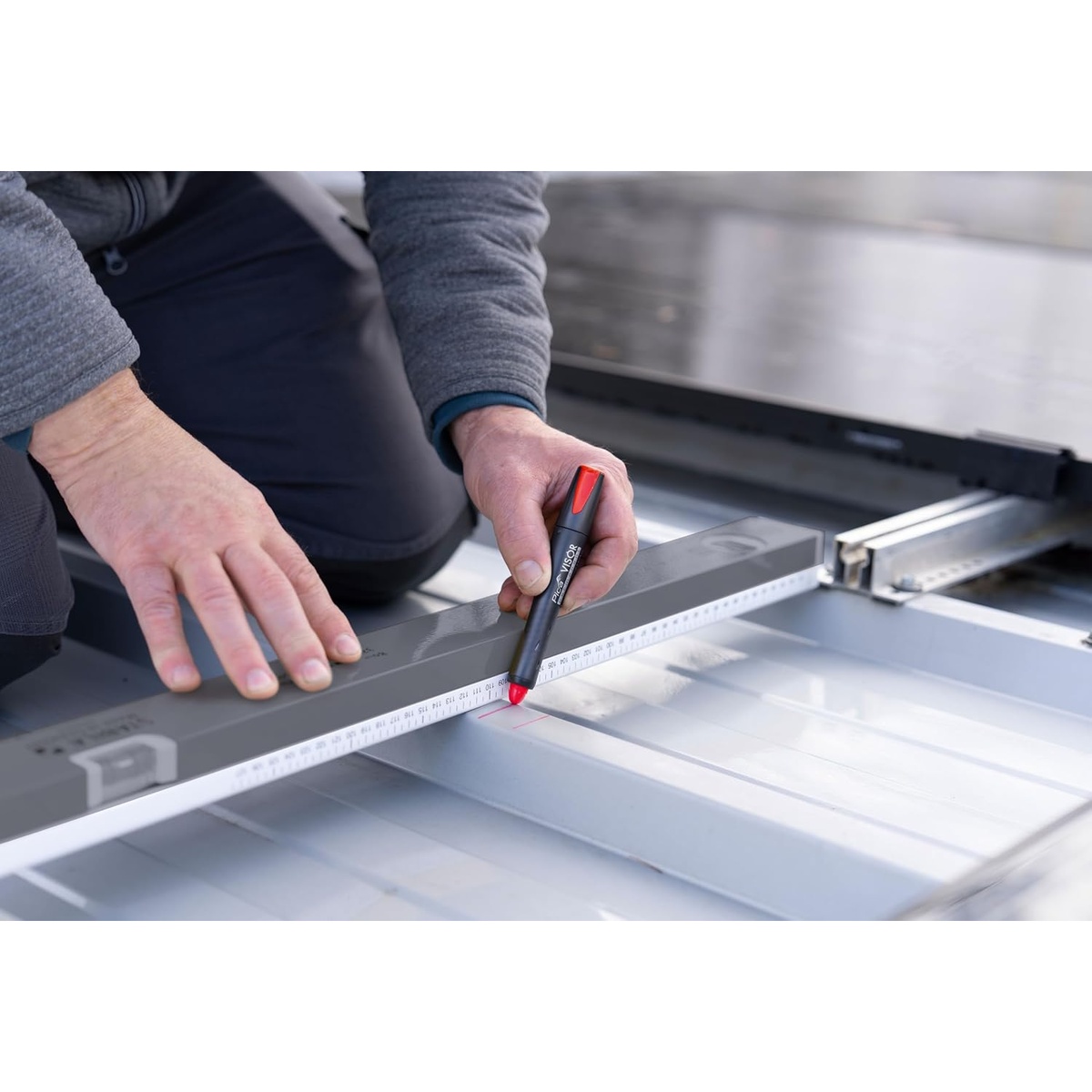 Pica Visor Permanent Industrial Marker making a layout mark against a straightedge on sheet material during measuring work