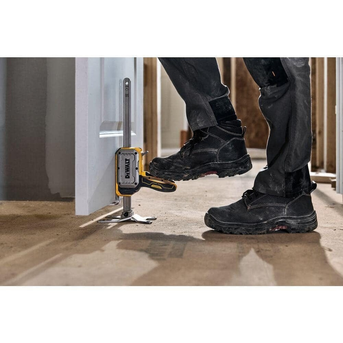 DEWALT DWHT83550 ToughSeries Construction Jack 8-3/4-in. Lift Height, 340 lb. Capacity, 2-Pack raising a door during interior installation on a jobsite floor