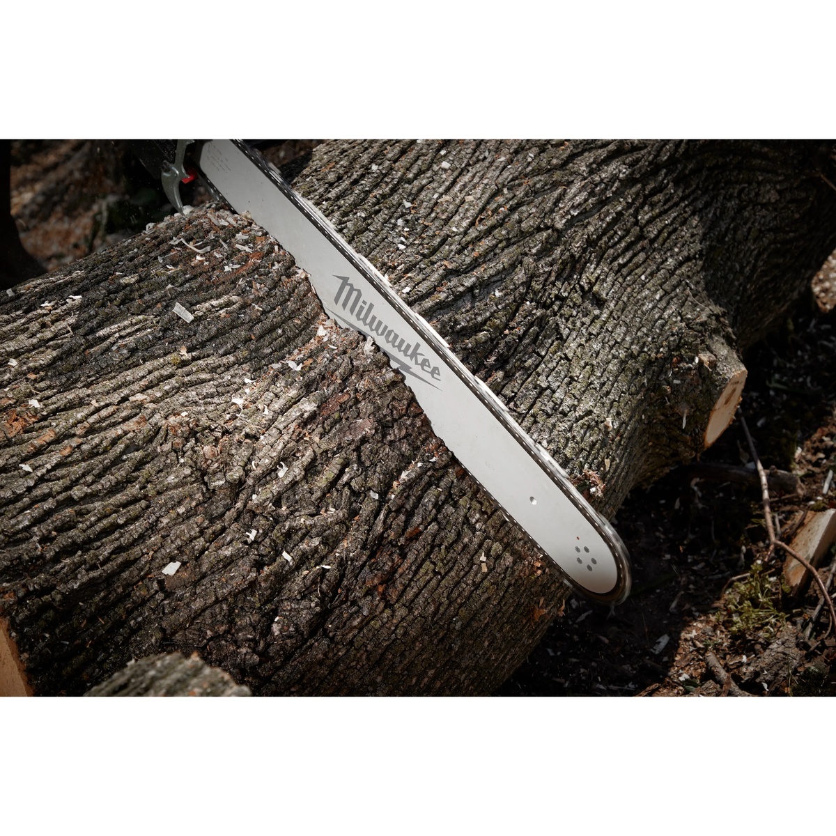Milwaukee 20 in. Chainsaw Bar Guide with .325 in. Pitch and .050 in. Gauge cutting through a large hardwood log during heavy outdoor cutting