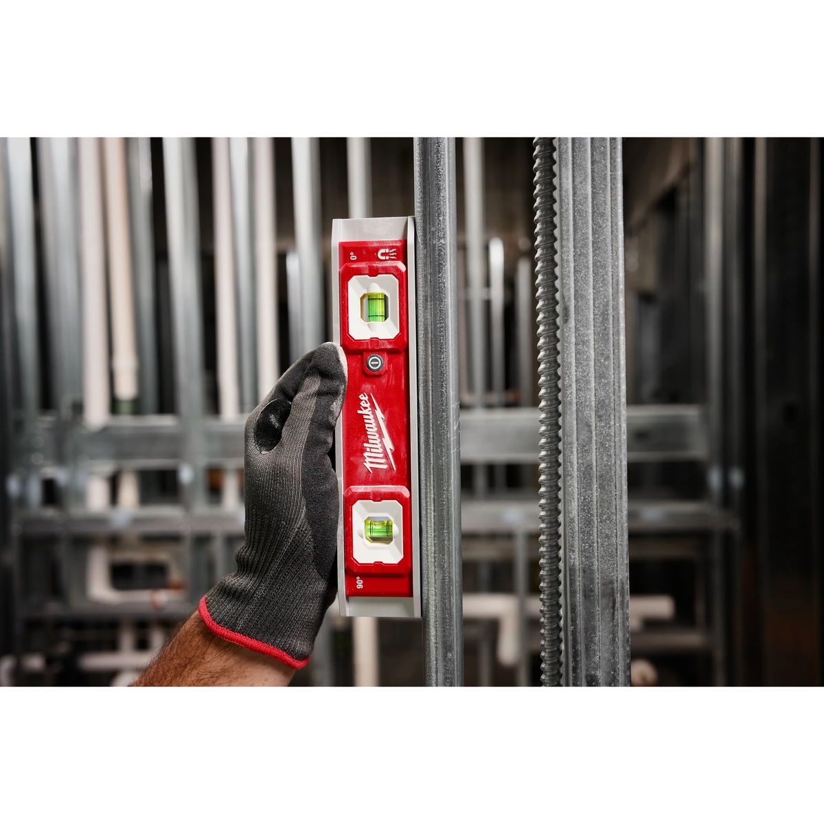 Milwaukee 48-22-5105 9 inch Torpedo Level with Lighted Vials checking plumb on metal stud framing in an indoor jobsite setting