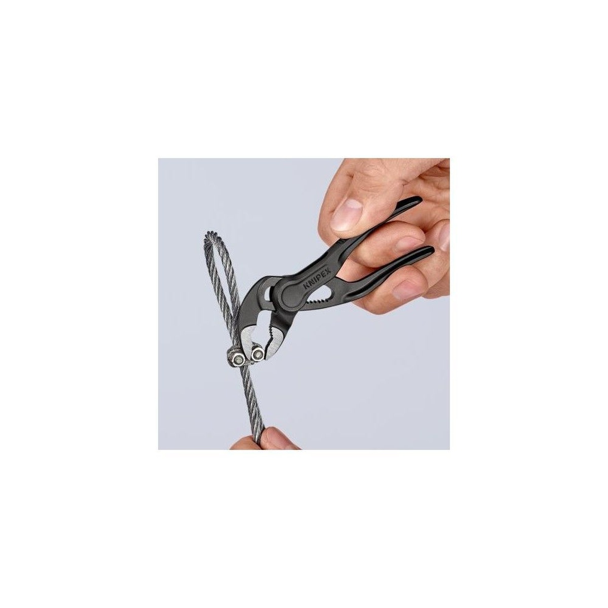 Knipex 87 00 100 SBA 4 in. Cobra XS Water Pump Pliers gripping small cable hardware during fine service work in a tight hand-held setup