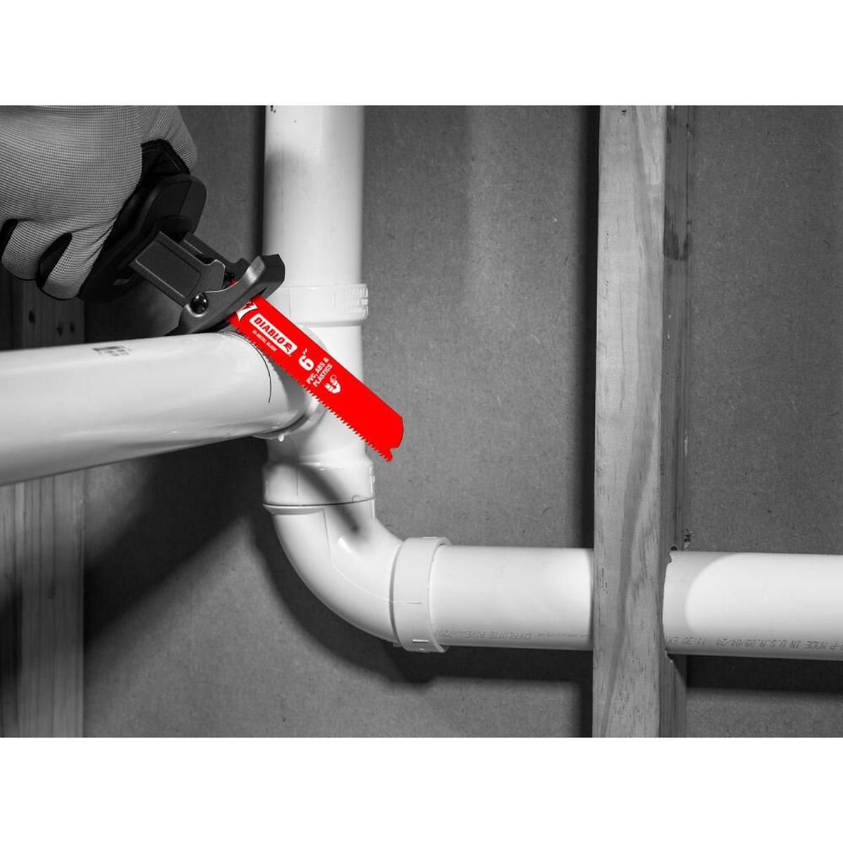 Diablo DS0611BPFG5 6 Inch 11 TPI Bi-Metal Reciprocating Blade cutting installed PVC pipe in a framed wall during plumbing work
