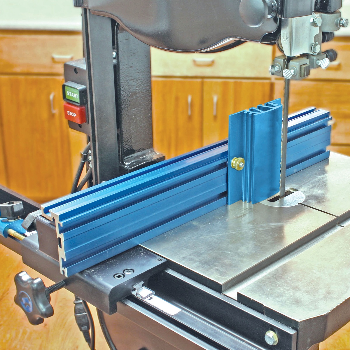 Kreg KMS7213 4-1/2 inch Resaw Guide mounted on a Kreg Precision Band Saw Fence beside a band saw blade in a woodworking shop for resaw cutting