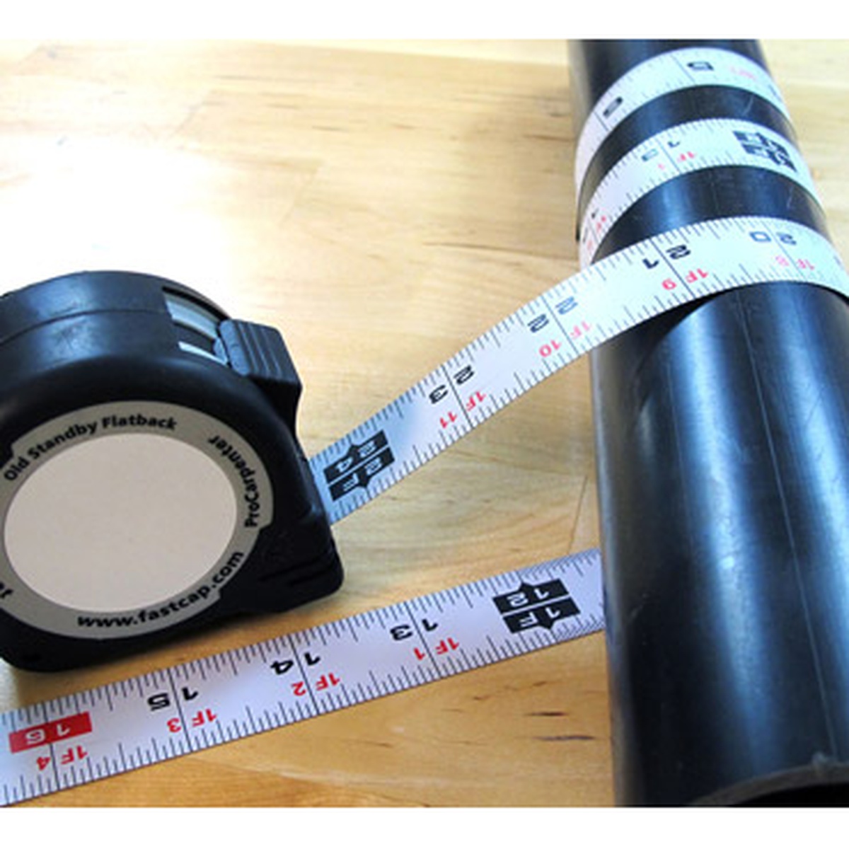 FastCap PMMR-FLAT 16 ProCarpenter FlatBack Tape Measure wrapped around round pipe for metric layout work on a shop bench