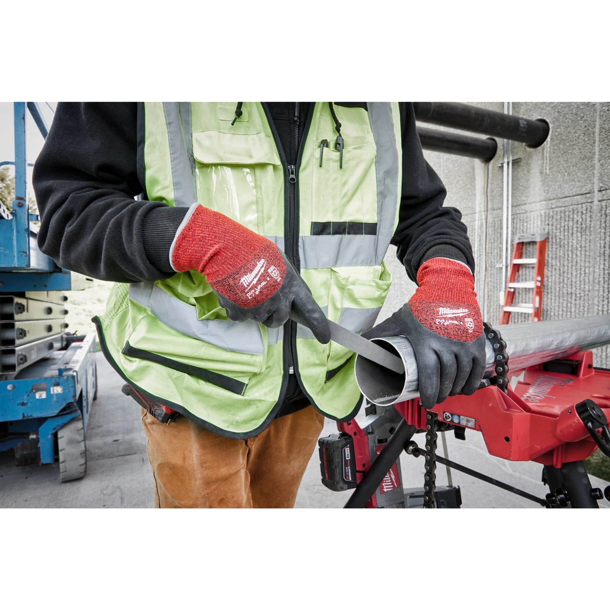 Milwaukee 48-73-7943 Cut Level 4 Winter Dipped Gloves used for cold-weather pipe handling on a construction jobsite