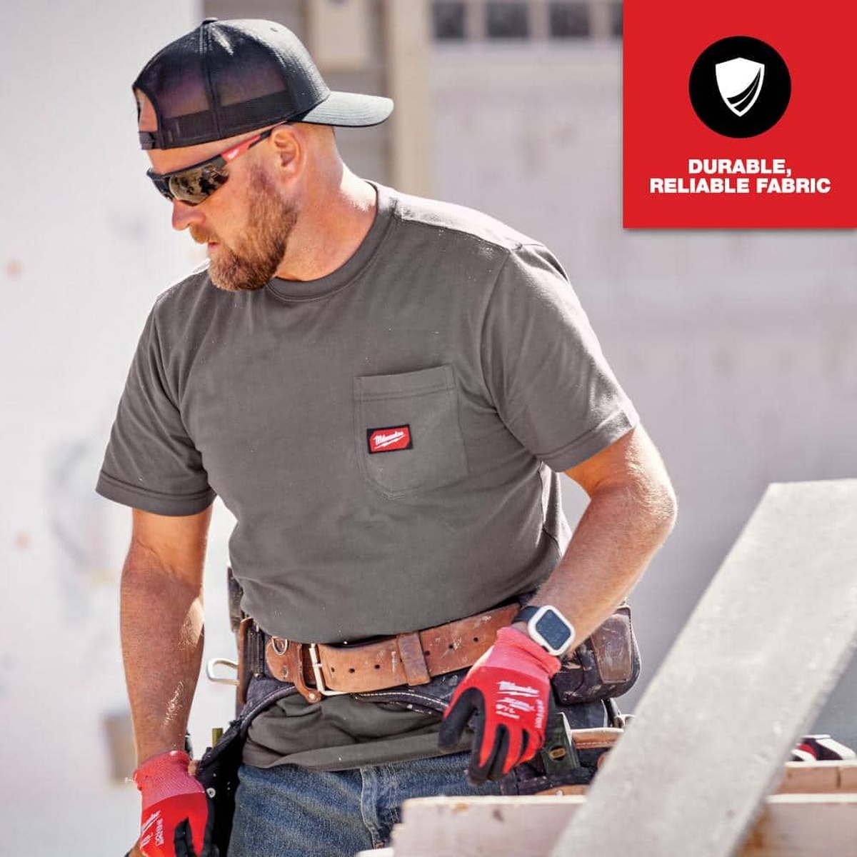 Milwaukee GRIDIRON Pocket T-Shirt Short Sleeve, Gray, Large worn on a construction jobsite while handling materials with a tool belt and gloves