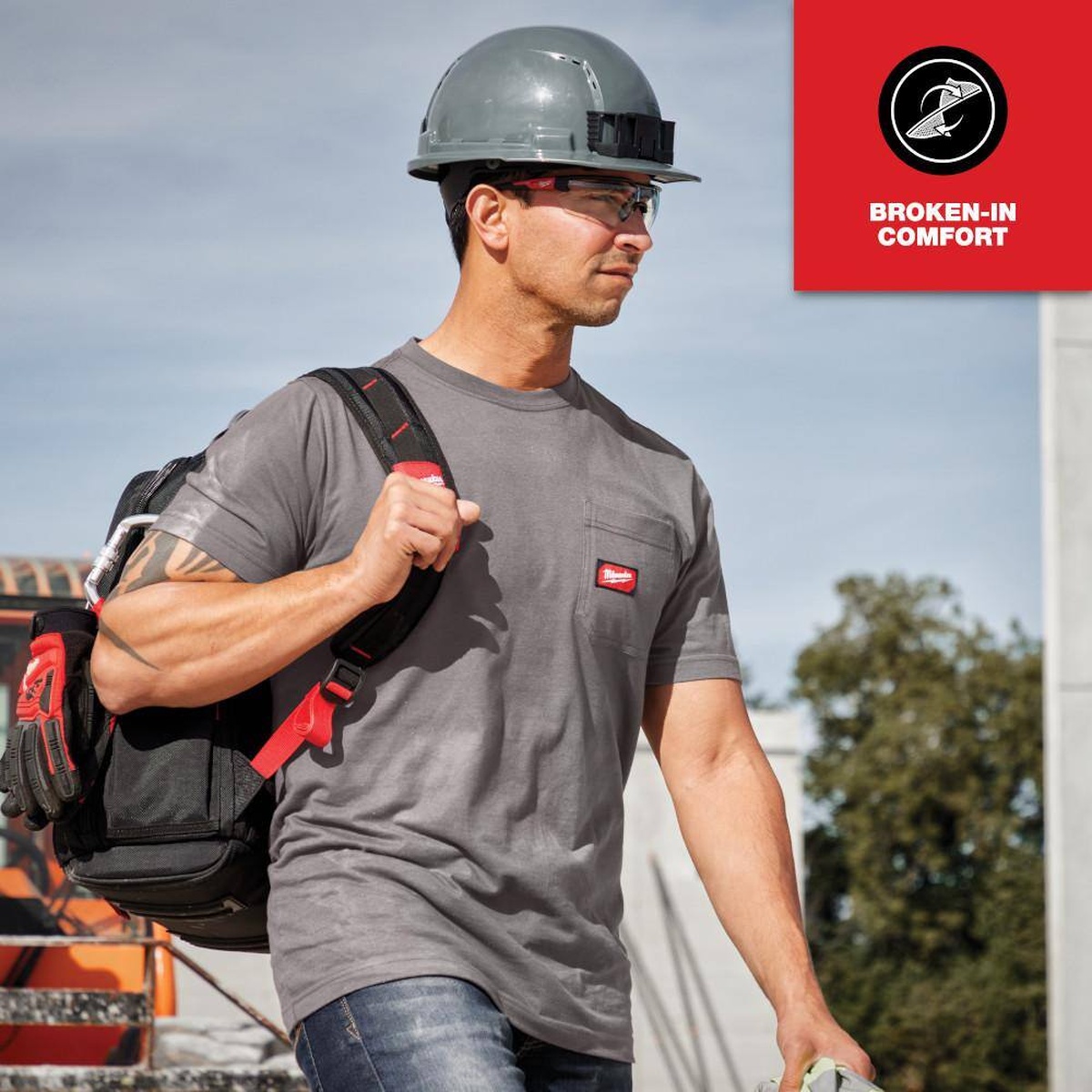 Milwaukee GRIDIRON Pocket T-Shirt Short Sleeve, Gray, Large worn outdoors on a worksite with hard hat and tool bag during active jobsite movement