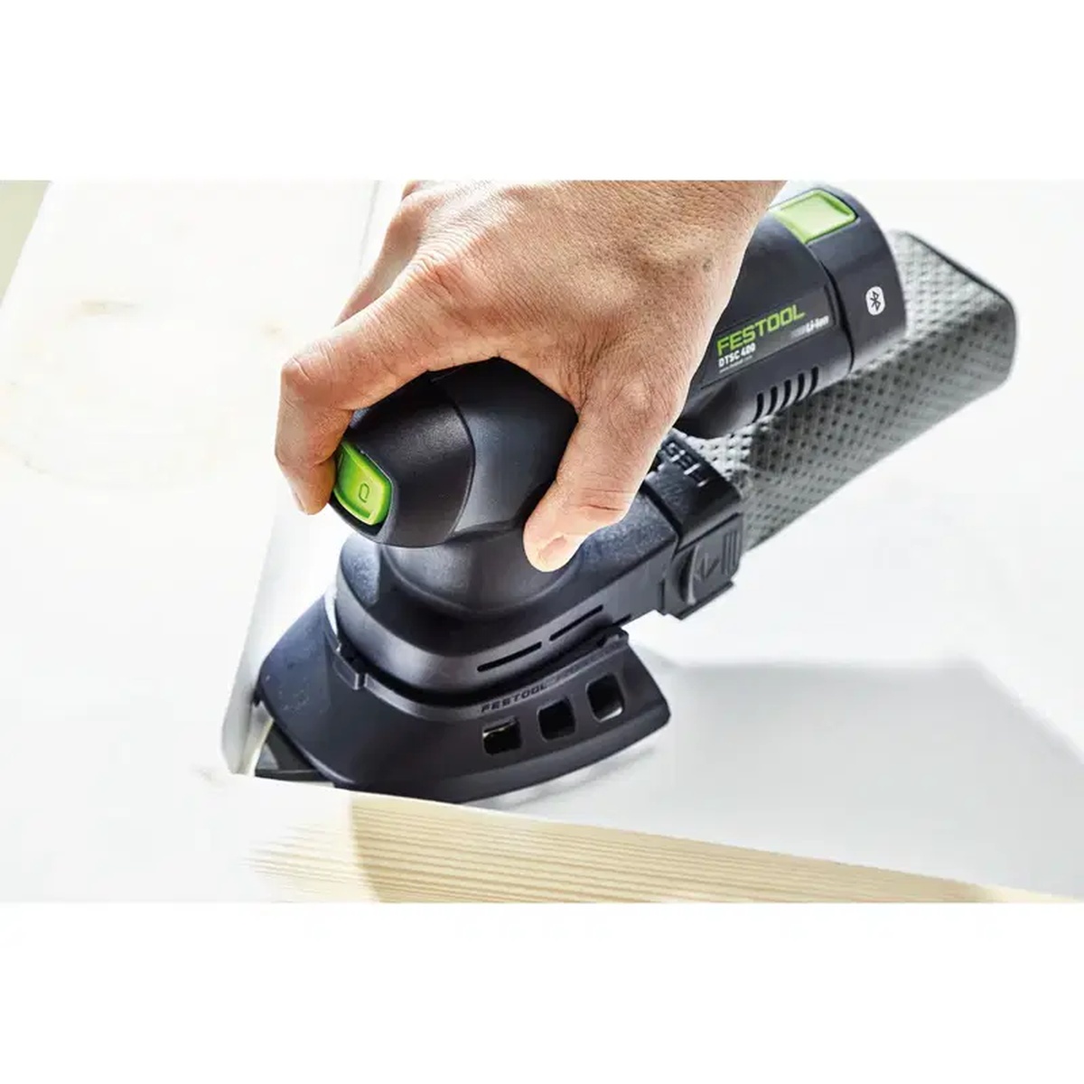 Festool STF DELTA/9 P80 RU2/50 Rubin 2 sanding sheets attached to a cordless detail sander shaping a wood edge in a workshop