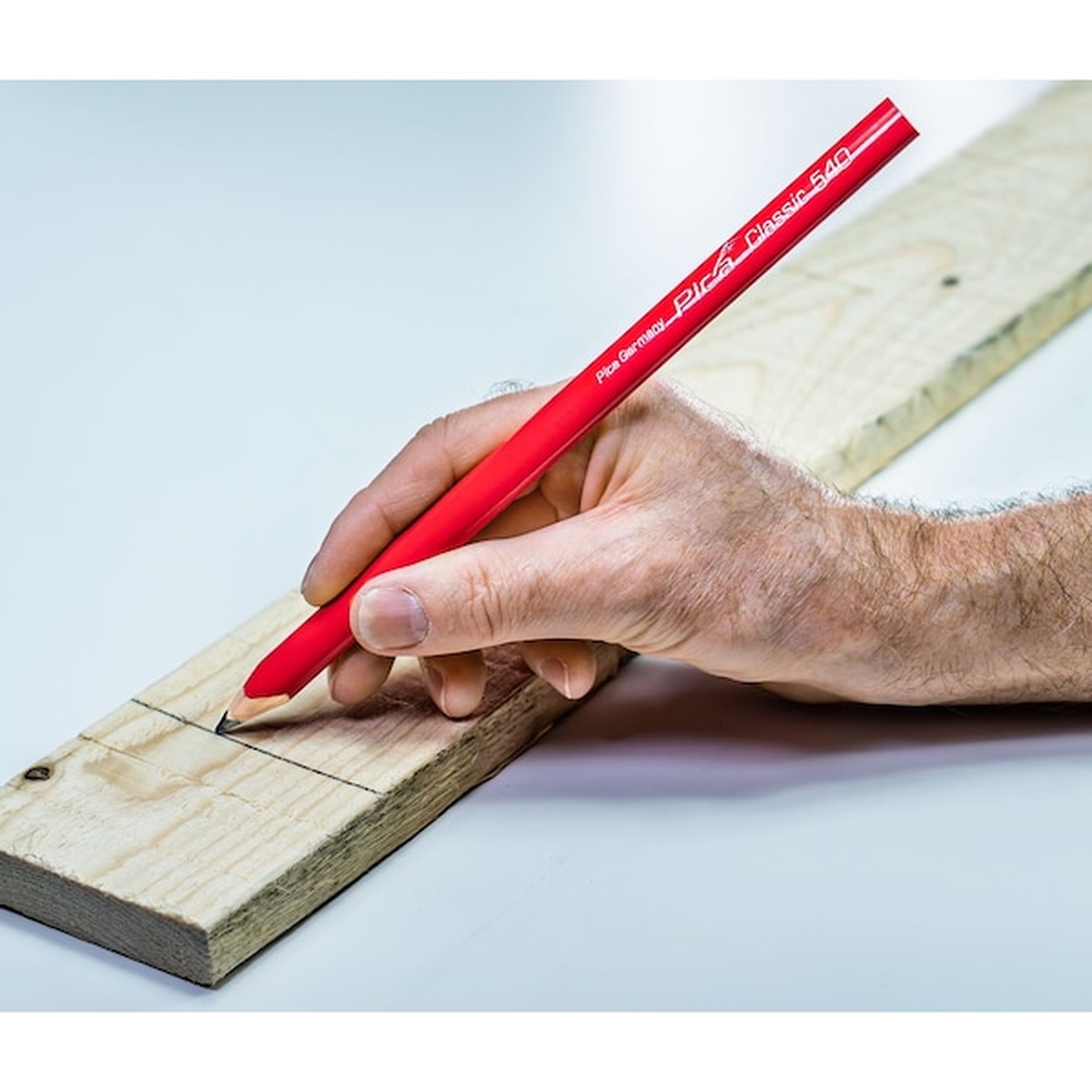 Pica 540/24 Red Carpenter Pencil marking a cut line on wood during carpentry layout work