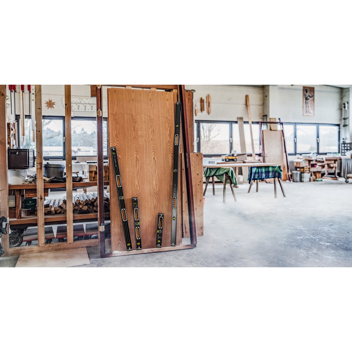 Stabila 37400 Level Set 196-2 Dark Shadow spirit levels staged in a woodworking shop beside a large wood panel for layout and installation work