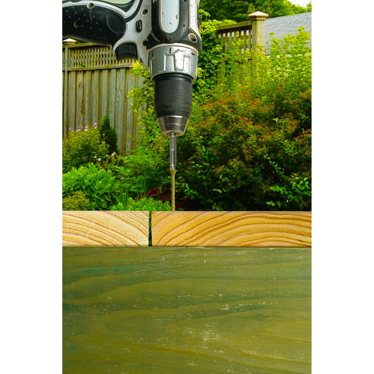 Simpson Strong-Tie DSVT3R770 Deck-Drive DSV Wood Screw aligned on an exterior deck board before driving in an outdoor backyard setting