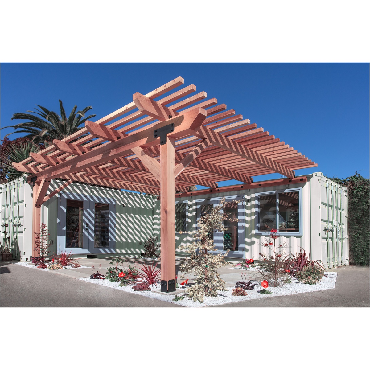 Simpson Strong-Tie APVB66 Outdoor Accents Avant Collection Black Powder-Coated Post Base used on a wood pergola over a patio to anchor posts to concrete in an outdoor backyard setting
