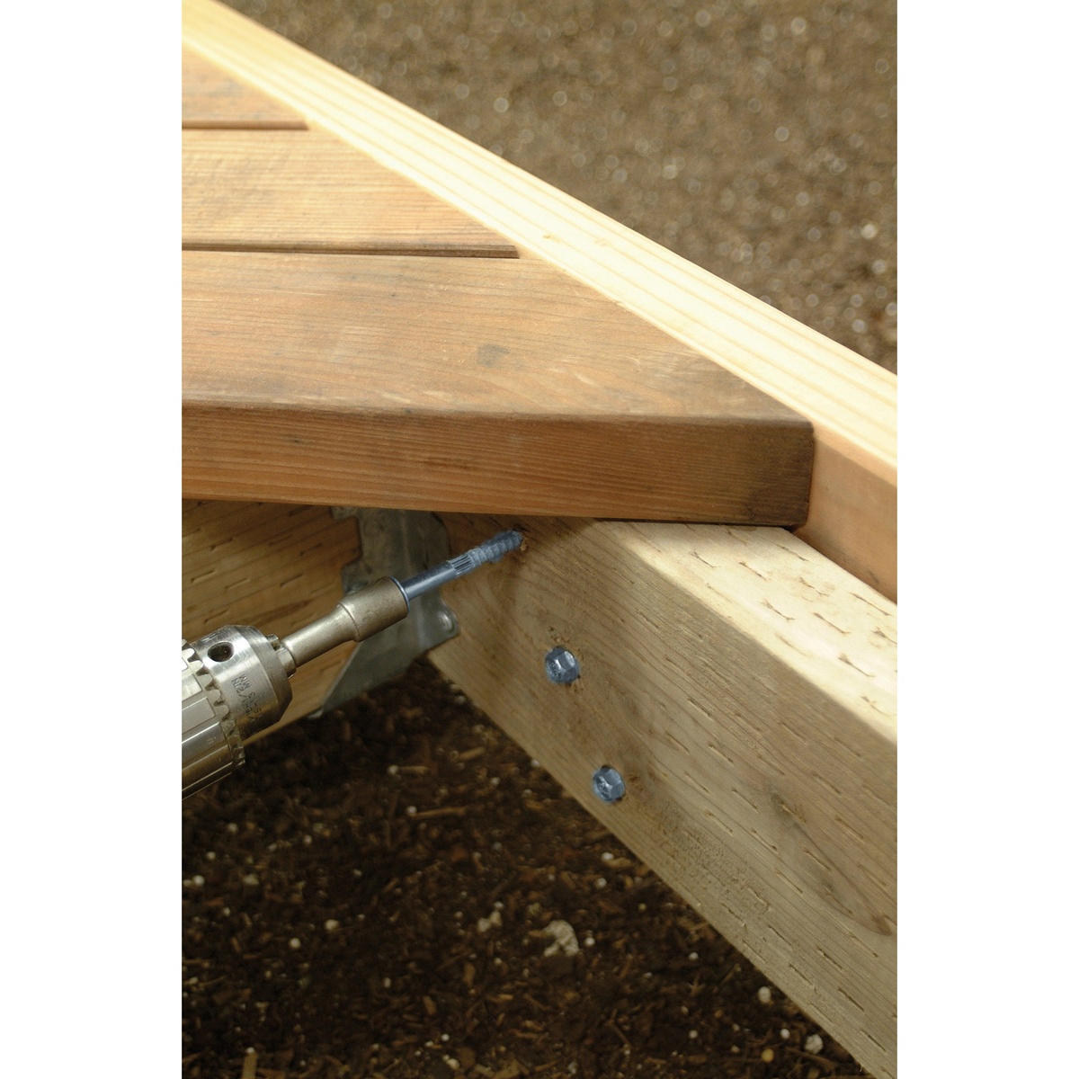Simpson Strong-Tie SDS25600 Strong-Drive SDS Heavy-Duty Connector Screw being driven into deck framing with a drill during exterior wood fastening