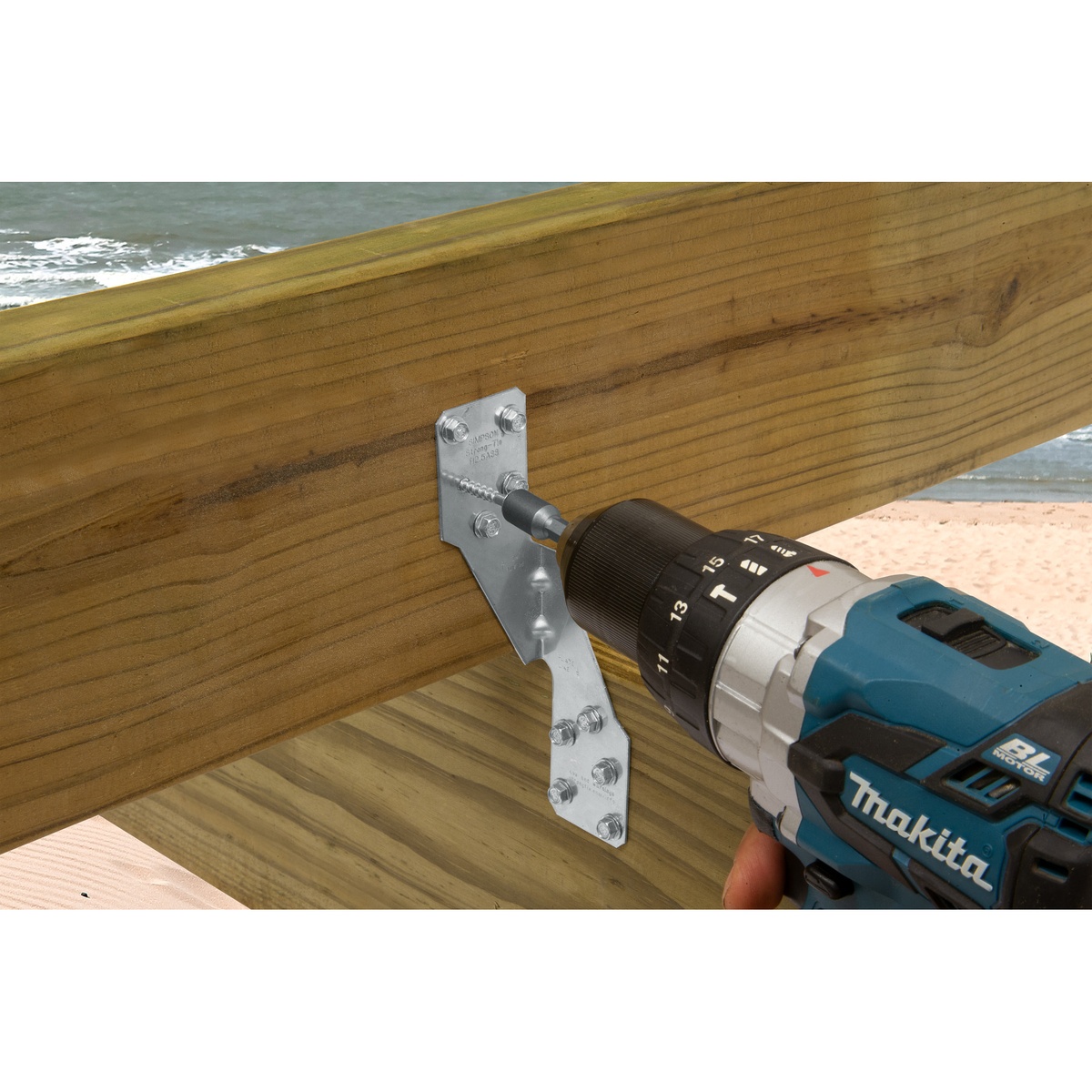 Simpson Strong-Tie SD9112SS-R500 Strong-Drive SD Connector SS Screw being driven into a stainless connector on exterior wood framing with a drill on a deck jobsite