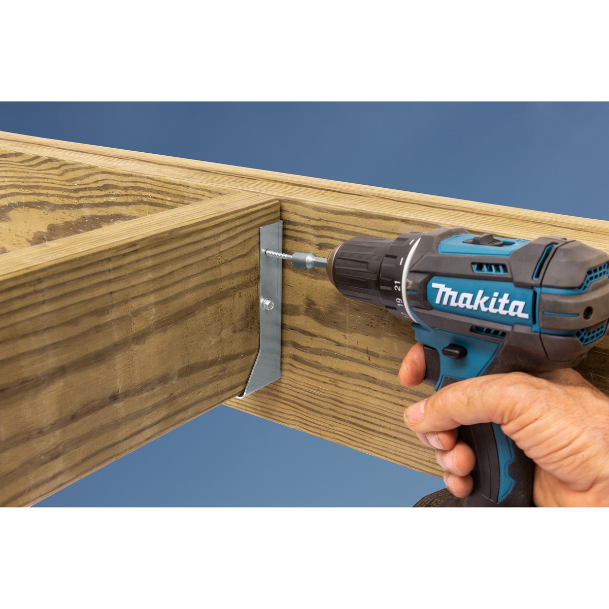 Simpson Strong-Tie SD9112SS-R500 Strong-Drive SD Connector SS Screw installed with a cordless drill into a joist hanger style connector in treated lumber