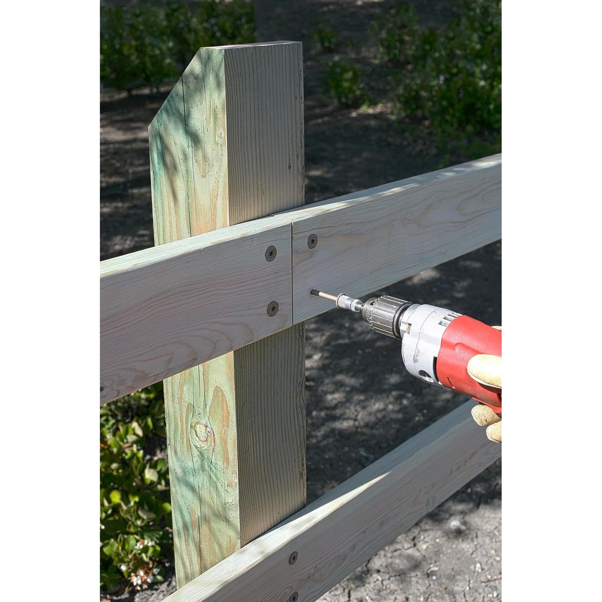 Simpson Strong-Tie SDWS22800DBMB Strong-Drive SDWS Timber Screws being driven into an outdoor wood fence rail and post connection, showing exterior structural fastening in treated lumber