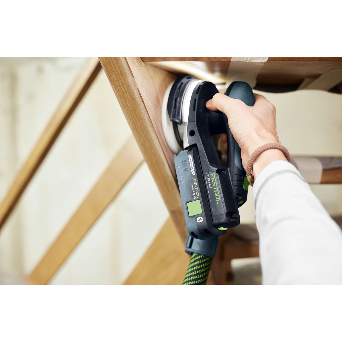 Festool PR ETSC 2 125 Protector for ETSC 2 125 Cordless Orbital Sander sanding a wood chair rail close to an inside edge during finish prep