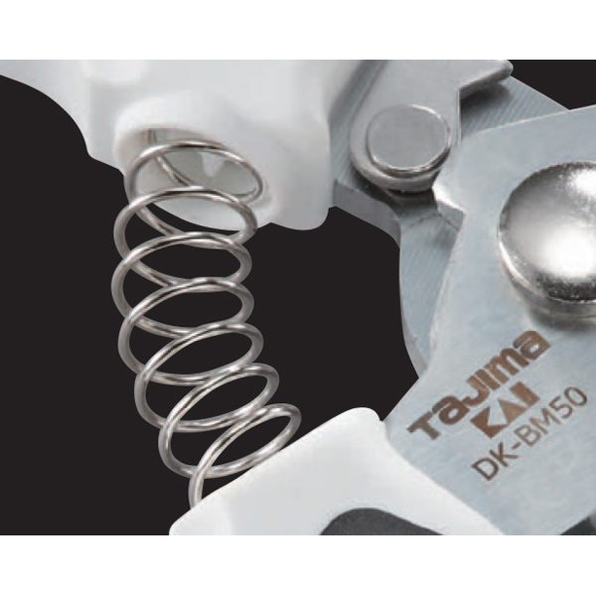 Close-up of Tajima VARIX Smooth Cut Snips spring mechanism at the pivot for repeated one-handed cutting on the jobsite