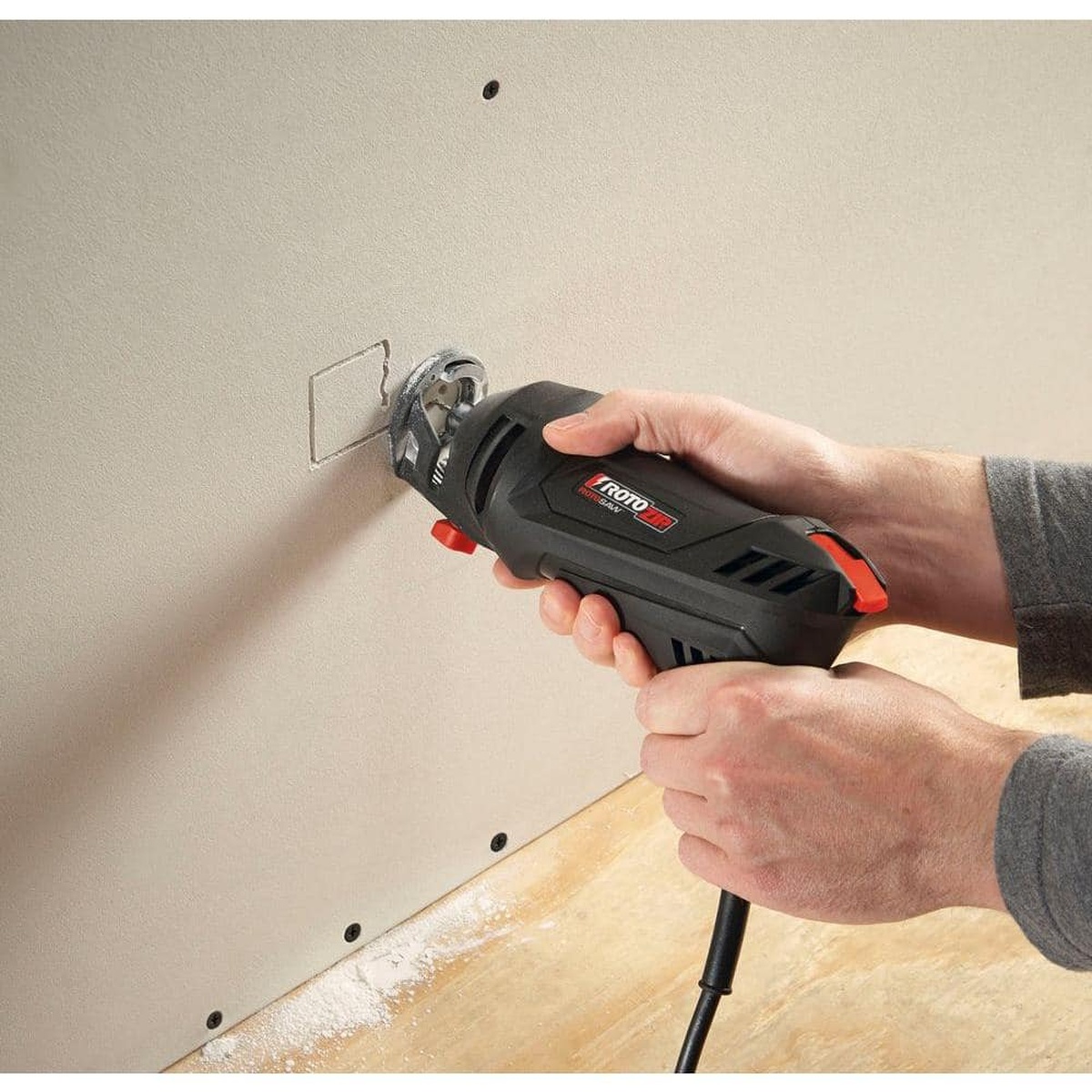 Rotozip GP8 1/8 in. Drywall Guidepoint Cutting Bits being used in a Rotozip spiral saw to cut an outlet opening in installed drywall during interior remodel work