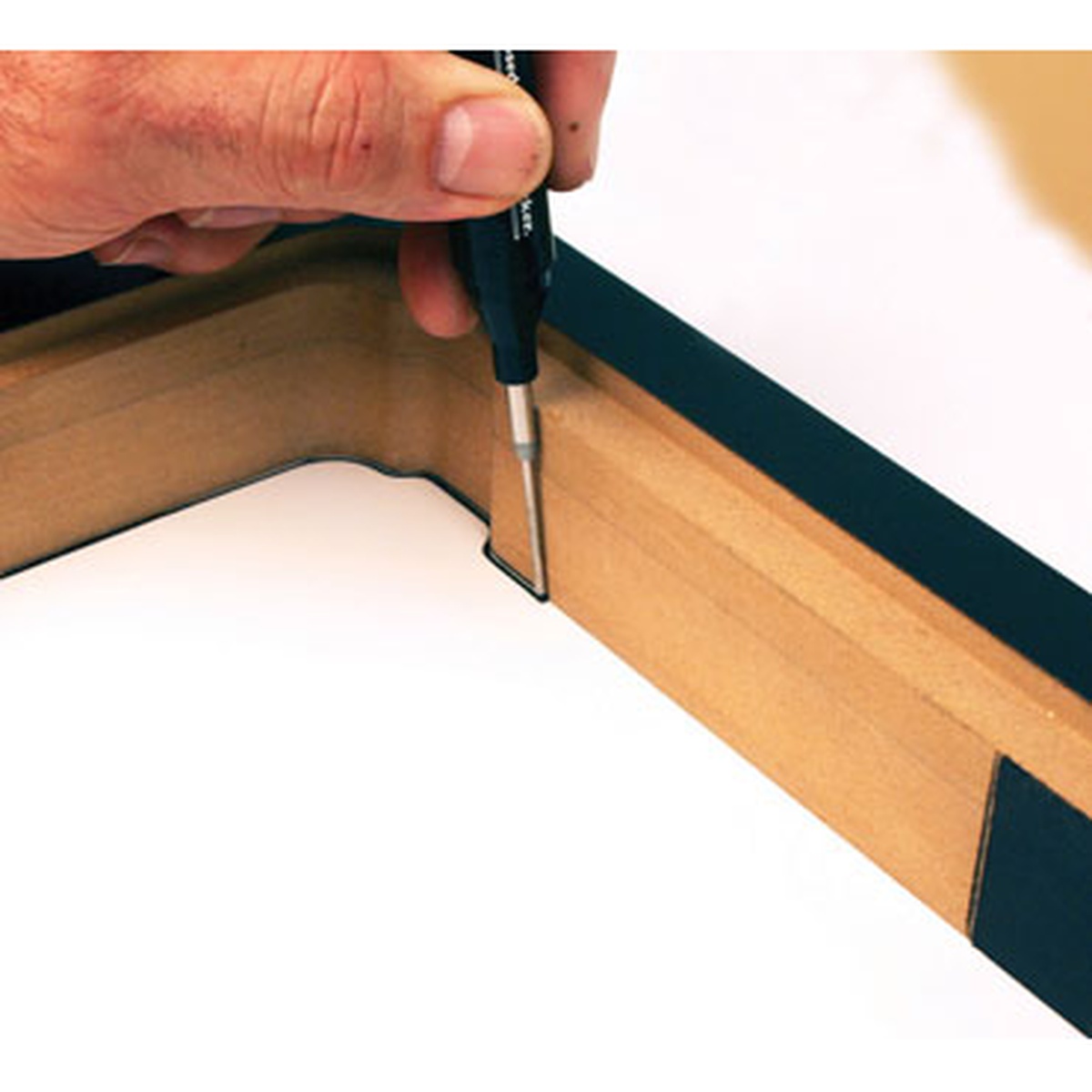FastCap Long Nose Marker marking a tight inside corner on a wood cabinet or trim piece during layout work