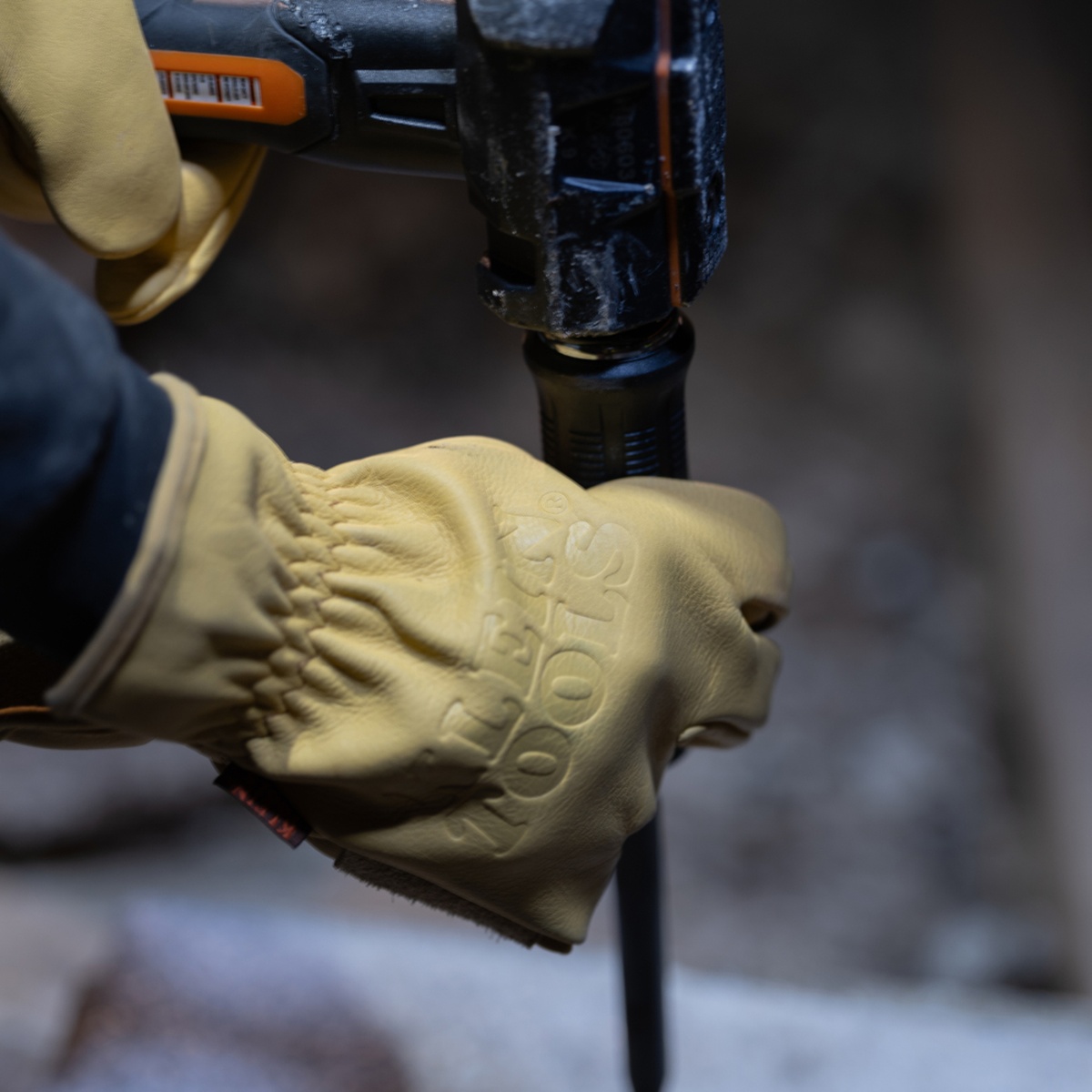 Klein 6007DD 5/16-Inch Keystone Demolition Driver being struck with a hammer by a gloved user during demolition work on a jobsite