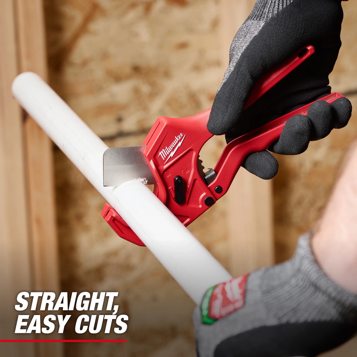 Milwaukee 48-22-4220 1-5/8 in. Ratcheting Pipe Cutter making a straight cut through white plastic pipe on a framed indoor jobsite