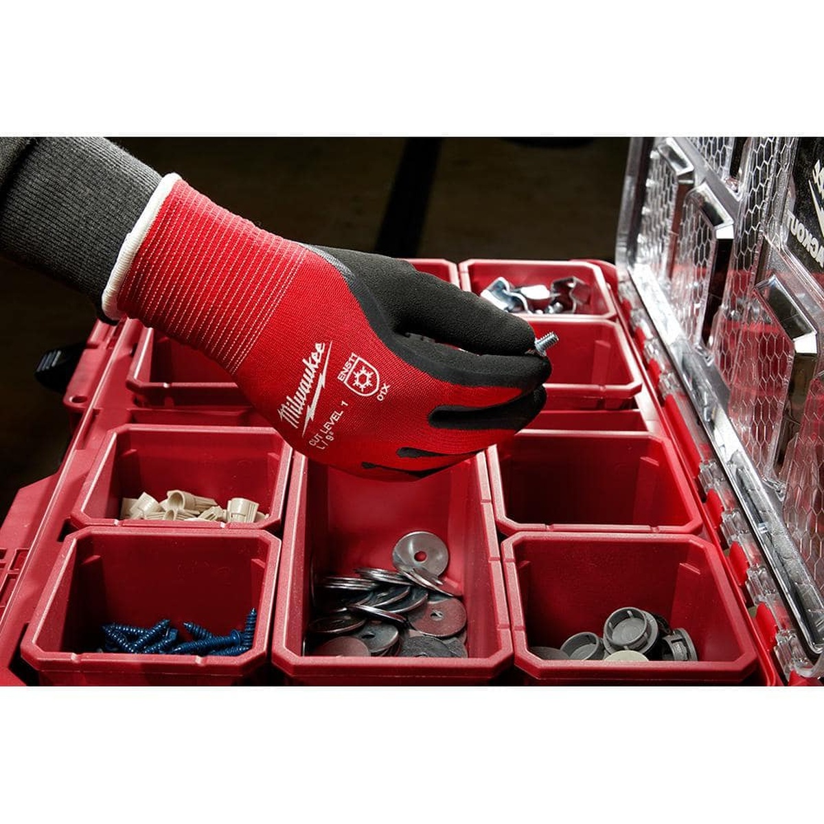 Milwaukee 48-22-8910 small cut resistant insulated gloves picking up hardware from an organizer tray during fastening work