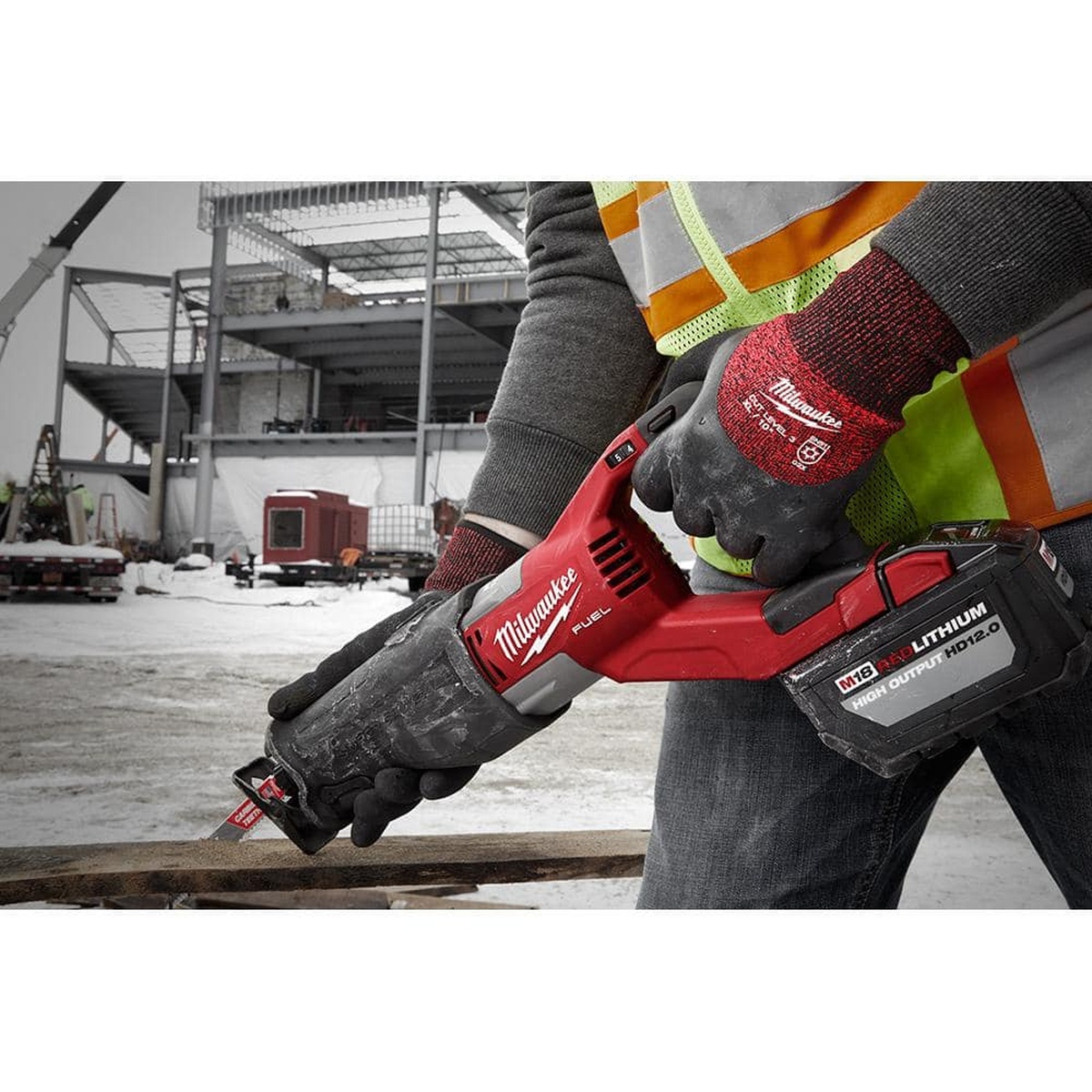 Milwaukee 48-22-8920 Cut Level 3 Winter Insulated Gloves operating a reciprocating saw on an outdoor jobsite in winter
