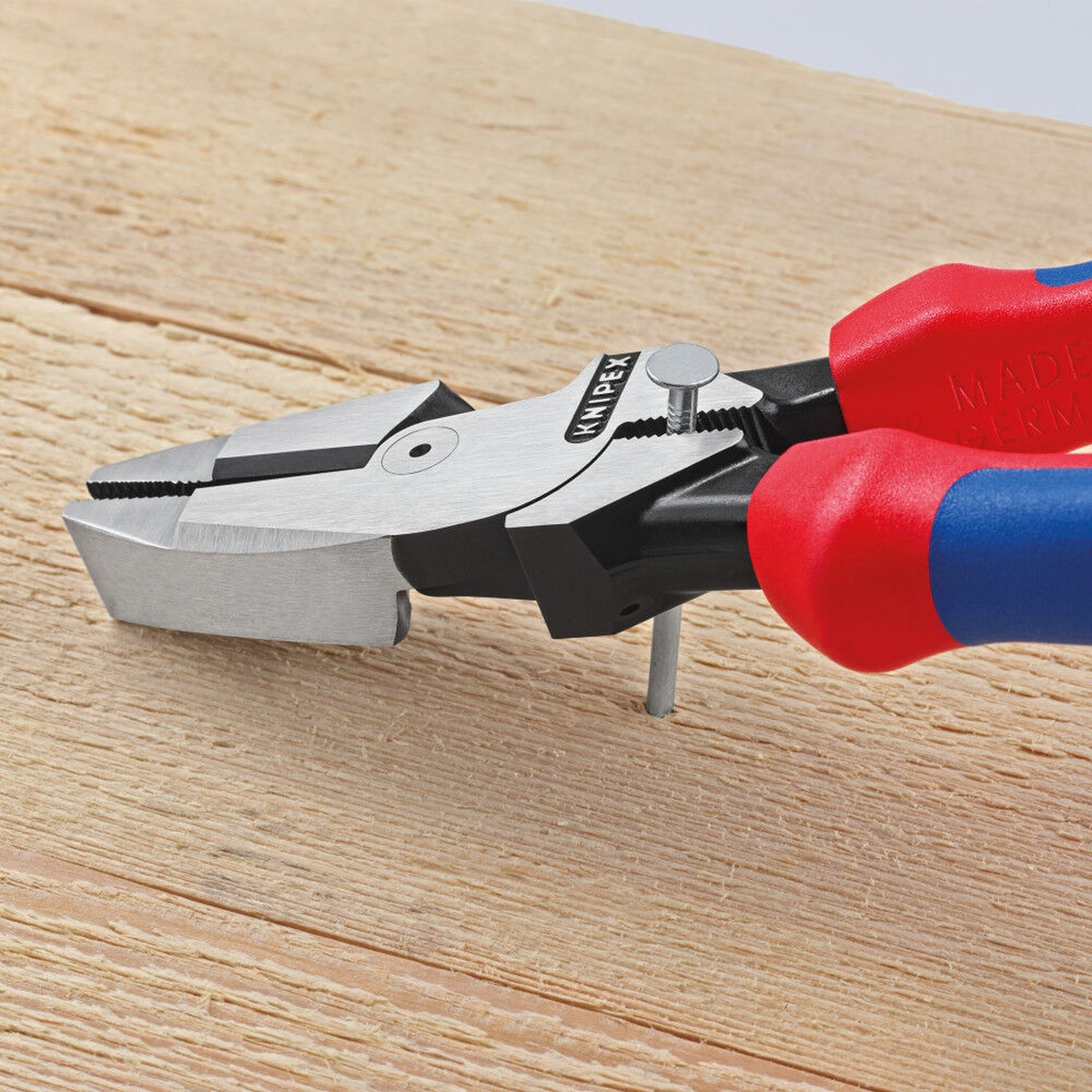 Knipex 09 02 240 SBA Lineman's Pliers pulling a nail from wood in a jobsite-style close-up on a work surface